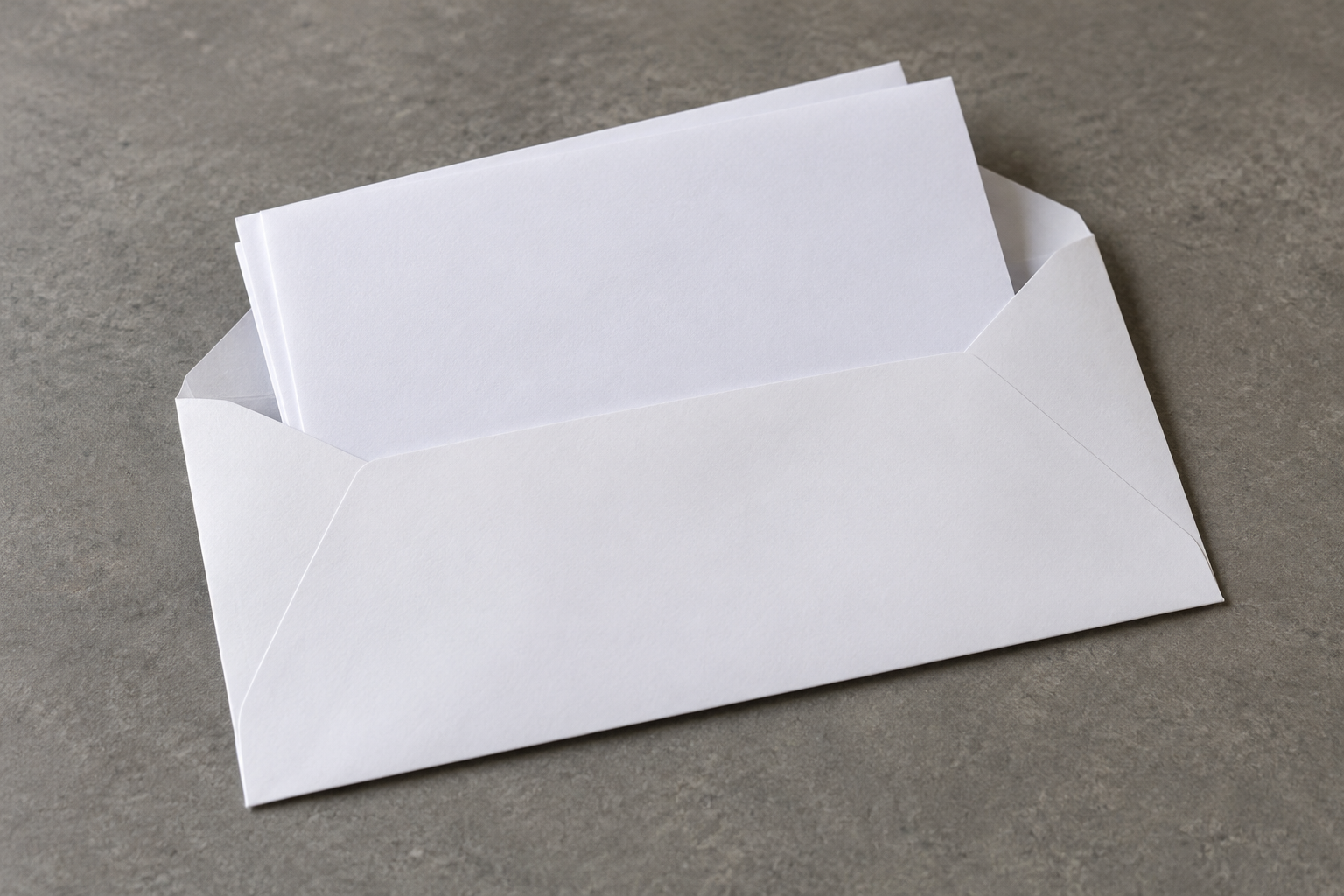 Folded plain sheets at the open throat of a white paper envelope